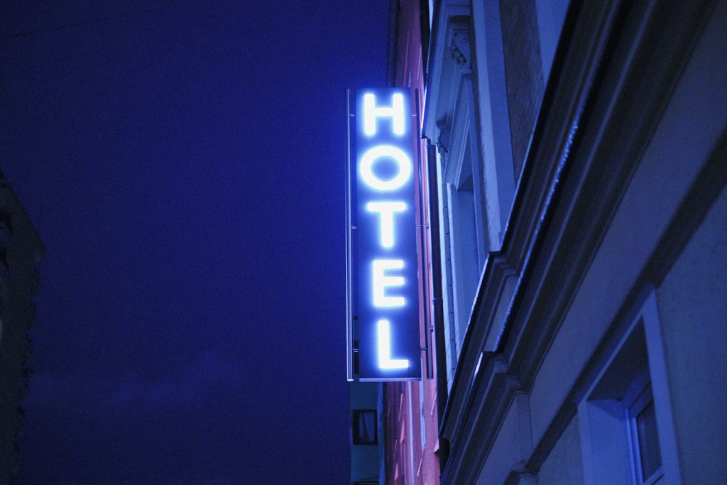 LED escrito "hotel" aceso durante a noite. Serve para ilustrar o upselling, técnica que ajuda no marketing para agência de viagens.